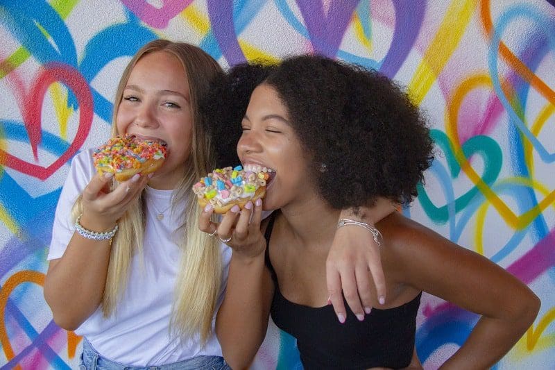 sundae donuts montauk two girl teens eating donuts colorful background instaworthy
