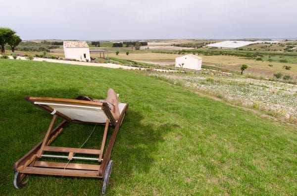 woman sitting on lawn chair overlooking organic farm