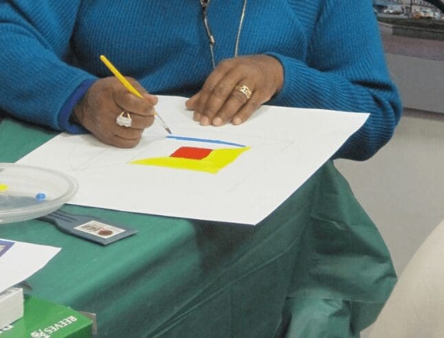 woman wearing blue sweater drawing pencil