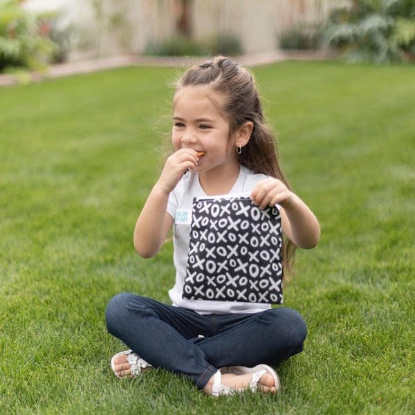 young girl eating snack in green grass