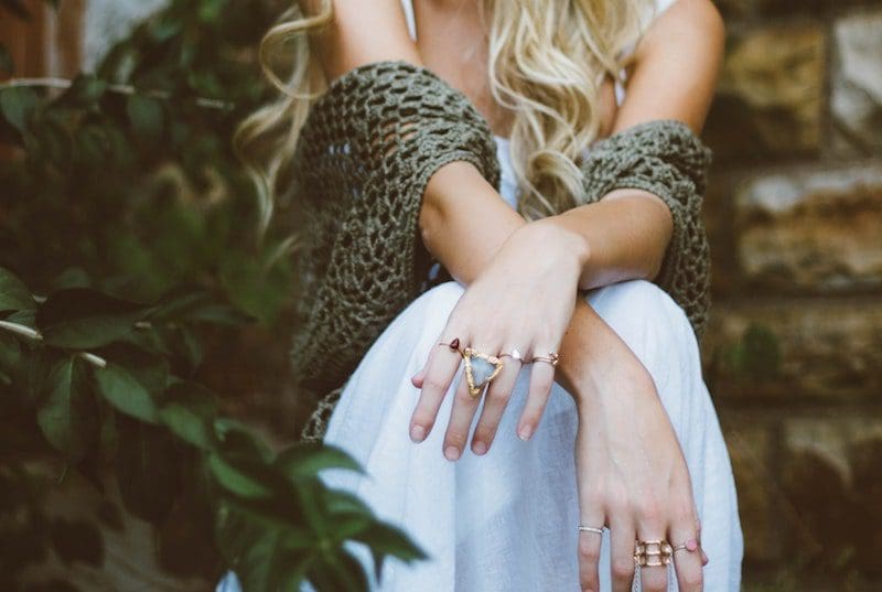 woman with blonde hair wearing rings and knitted shawl