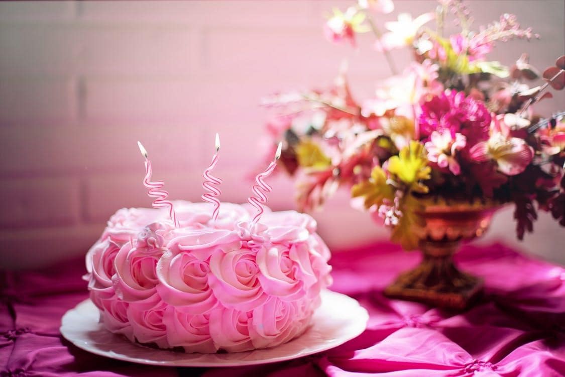 pink birthday cake with candles