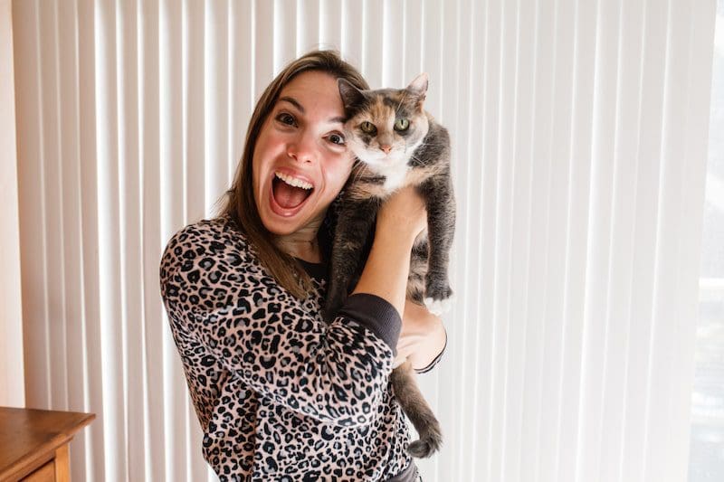 Vanessa Gordon and her cat Amy in bedroom smile