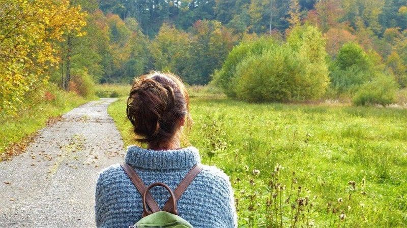 woman hiking with blue knitted sweater trail and backpack