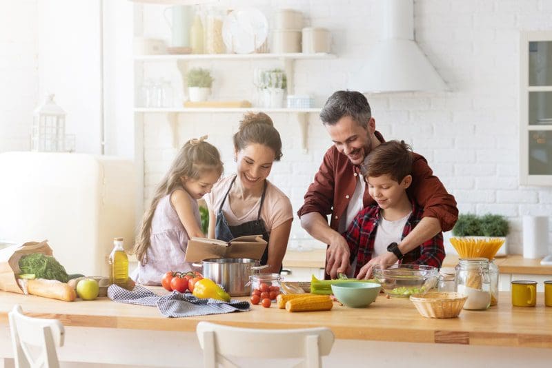 family cooking dinner together in beautiful kitchen