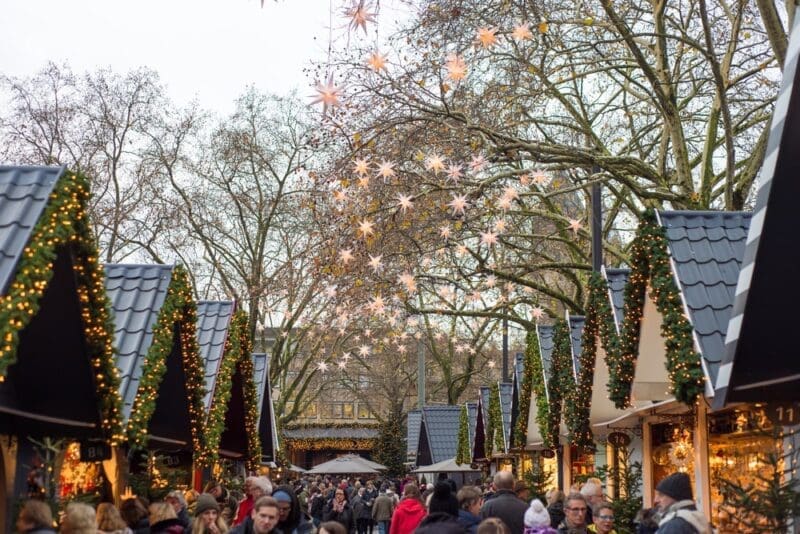 cologne germany christmas market stalls people shopping triangle roofs