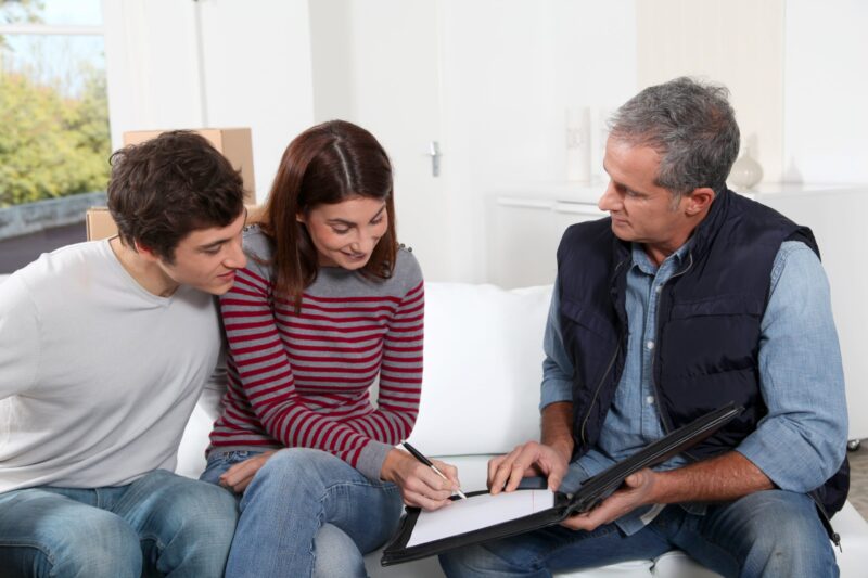 couple signing rental property buying home agreement