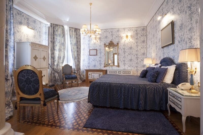 elegant bedroom with blue comforter and wallpaper