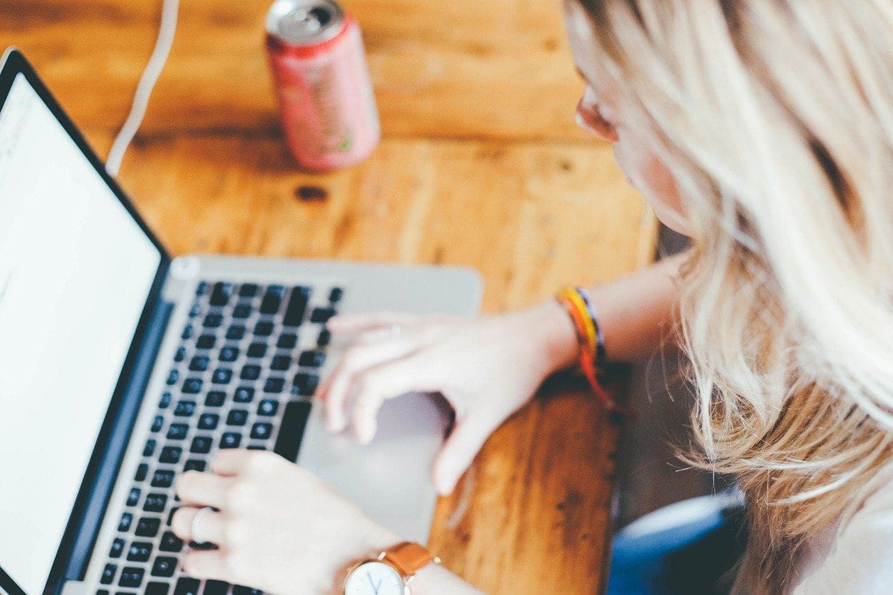 woman searching researching on a laptop blonde hair