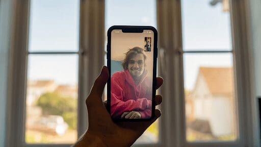 connecting with a family member or friend while abroad phone in front of window