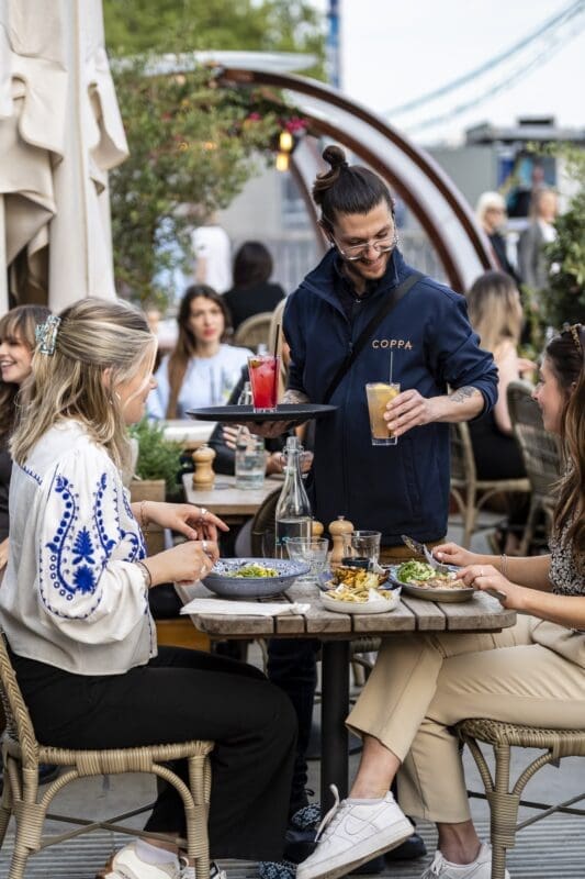 two girls ordering food at restaurant waiter