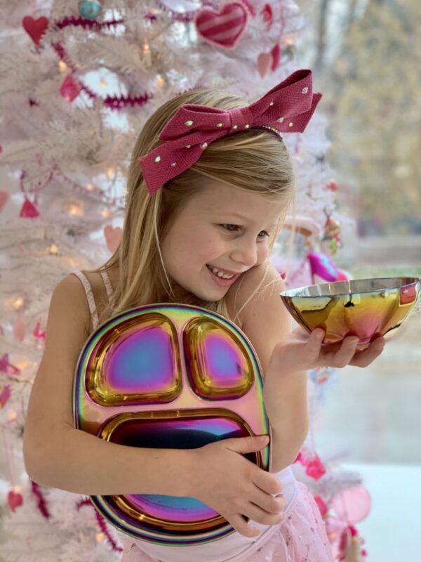 girl holding sustainable tableware at christmas tree