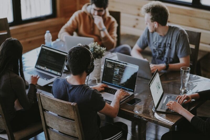 students at university studying together computer laptop