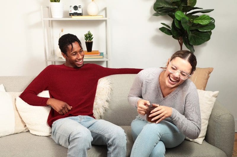 couple man woman relaxing and laughing on sofa