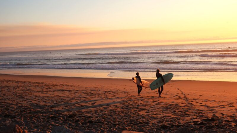 surfers at the ocean sunrise peaceful