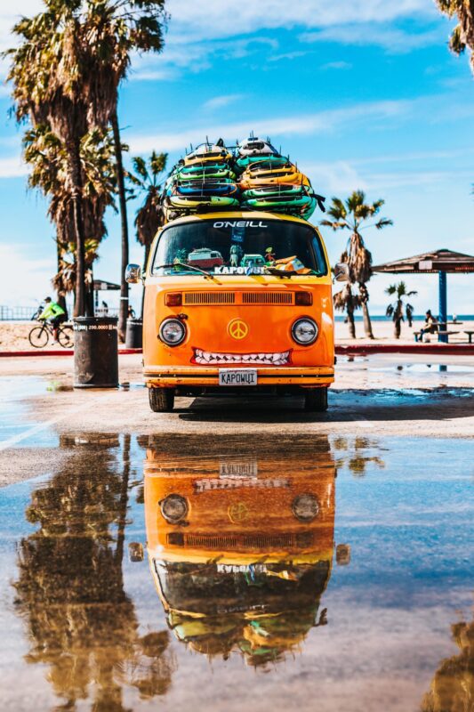 surfboards on top of orange van hawaii