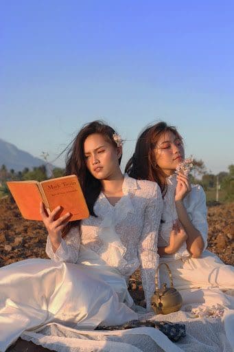 girls reading mark twain outside