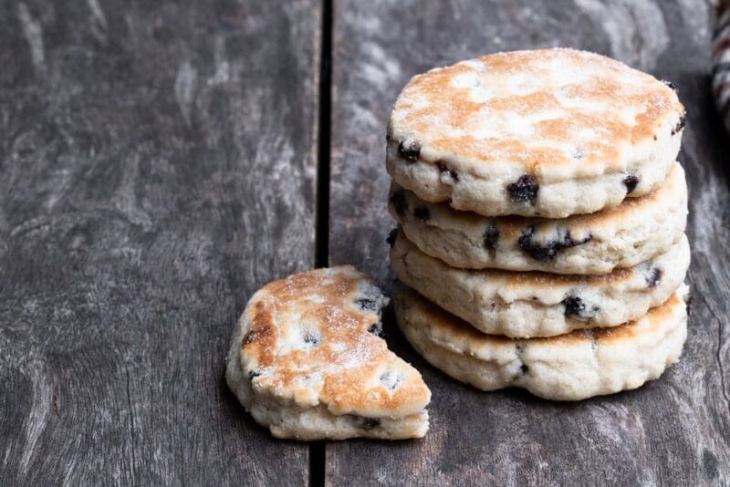 Stack of iced Welsh cakes on rustic wooden table