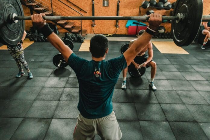 man lifting barbells at gym