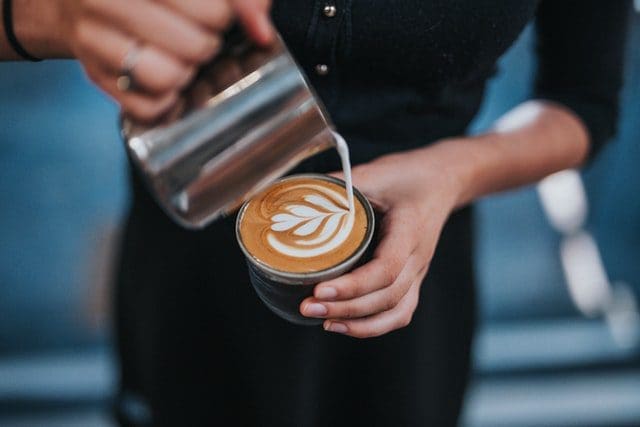 barista making pouring latte