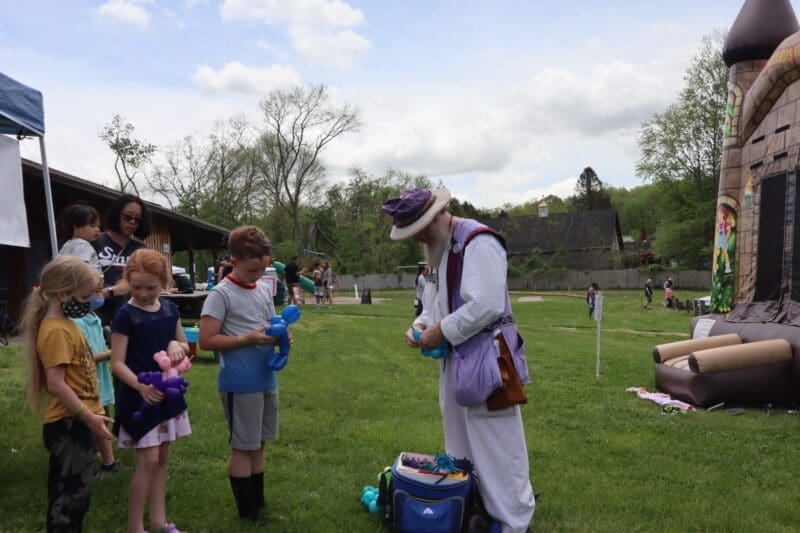 man making balloon animals at fair