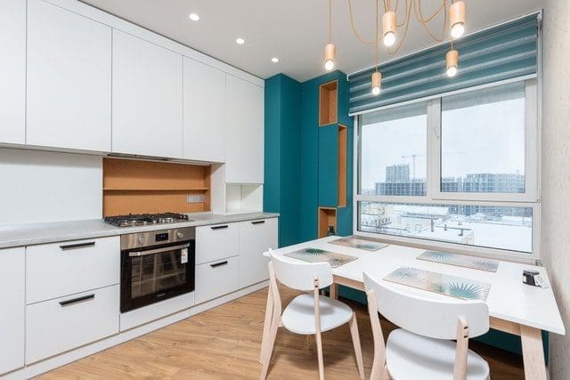 Contemporary kitchen interior with table under shiny light bulbs