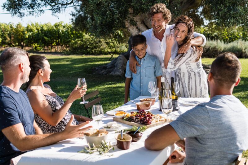family at table together outside drinking wine