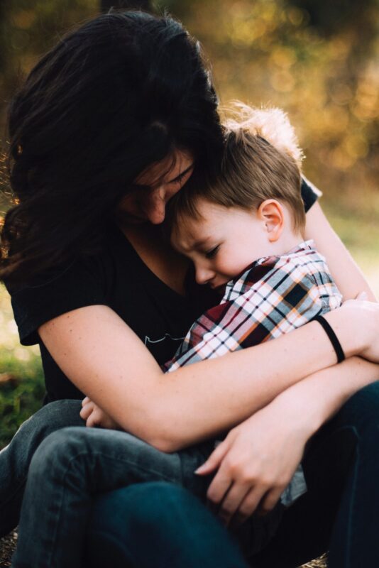 mom comforting son in arms