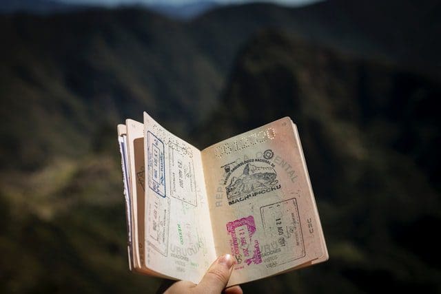 person holding open passport with stamps