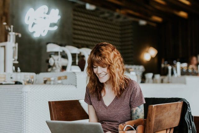 red haired woman working at computer