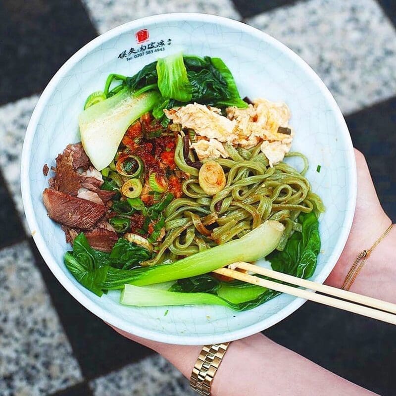 spinach noodles in bowl with vegetables