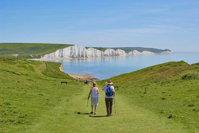 couple walking open field near cliff relaxation