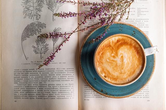latte art mug on an open book