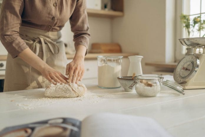 person baking bread at home kneading dough