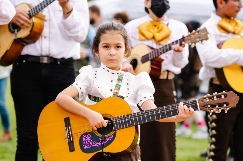 young girl playing guitar at festival