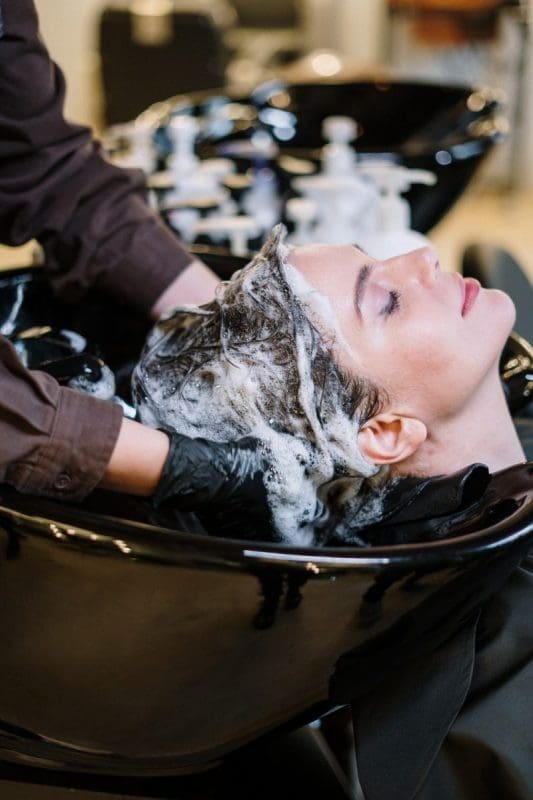 woman washing woman's hair at hair salon