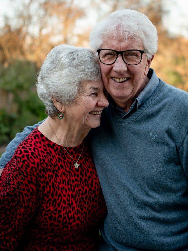 happy elderly couple in fall smiling