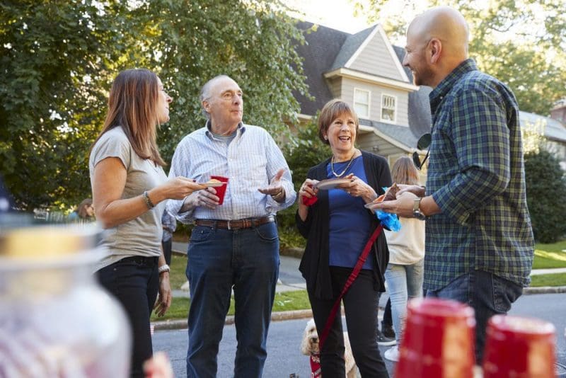 people standing chatting outside home party