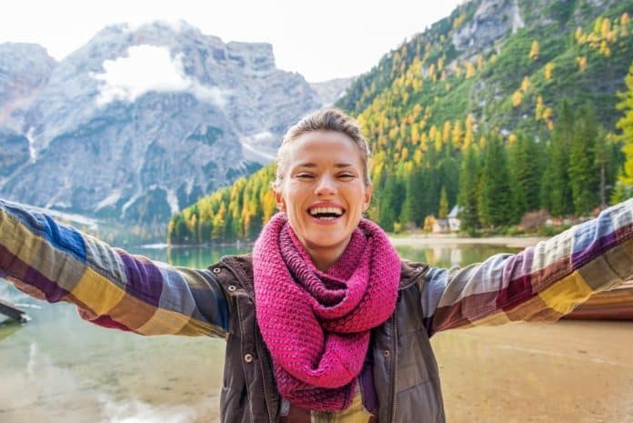 Happy young woman making selfie on lake braies in south tyrol