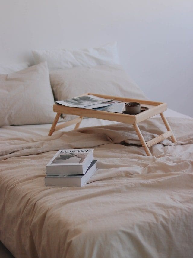 Books and bed table laying on double bed