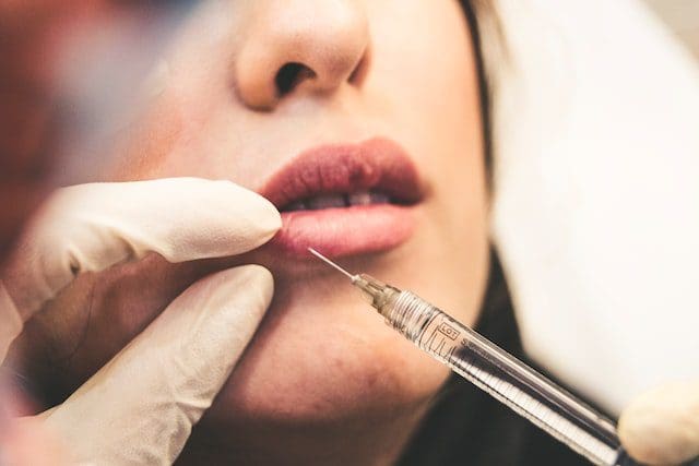 woman receiving lip injections botox