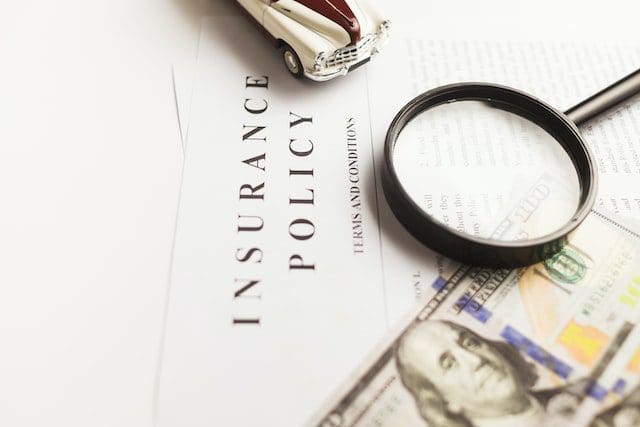book on insurance policy with magnifying glass