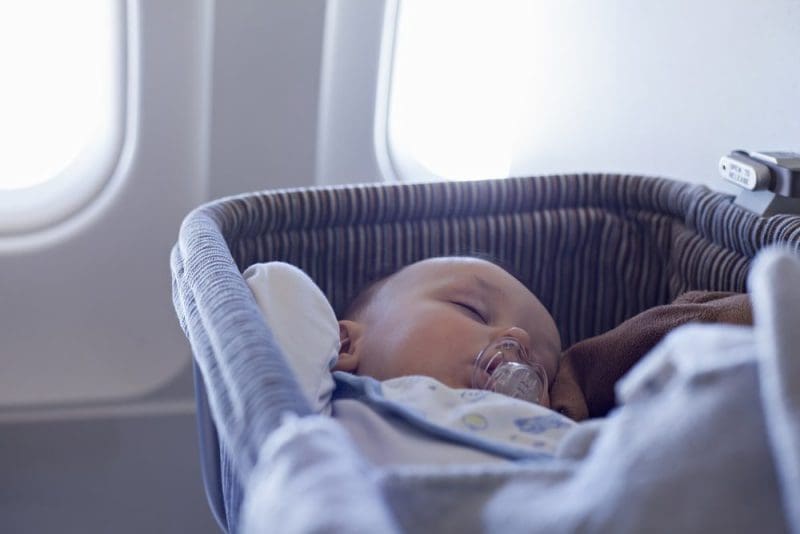 Baby Boy Sleeping In Bassinet On Airplane