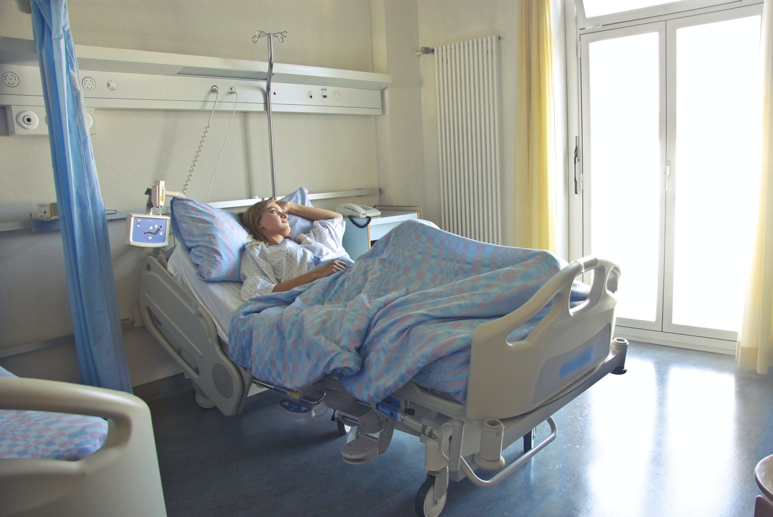 woman in hospital bed looking out window