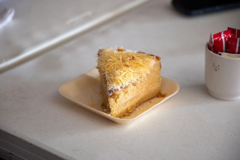 slice of cake with shredded cheese on sustainable bamboo plate