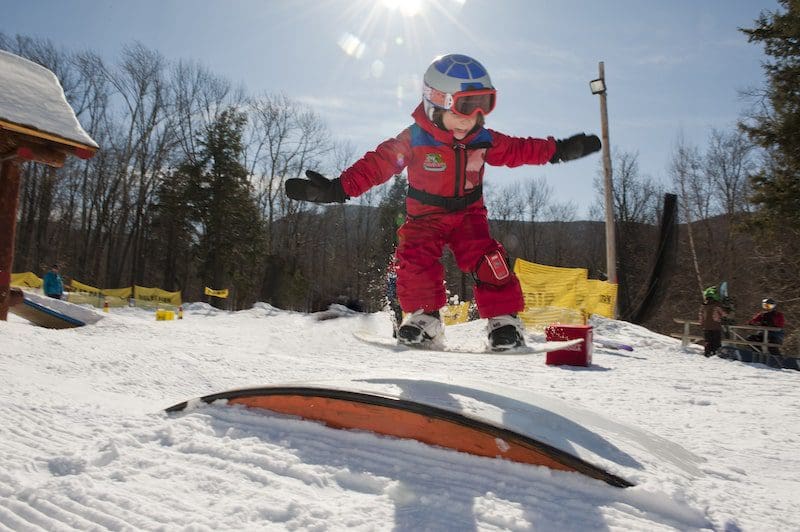 young child snowboarding in Vermont
