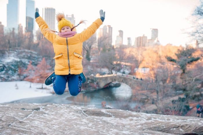 Adorable little girl with view of ice-rink in Central Park at New York City