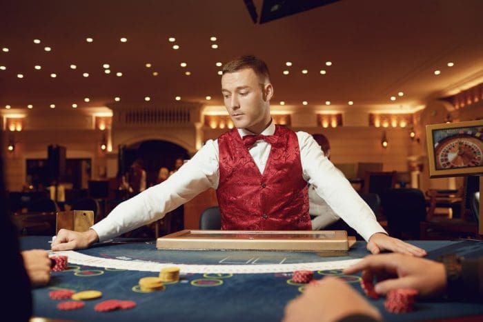 Croupier holds poker cards in his hands at a table in a casino