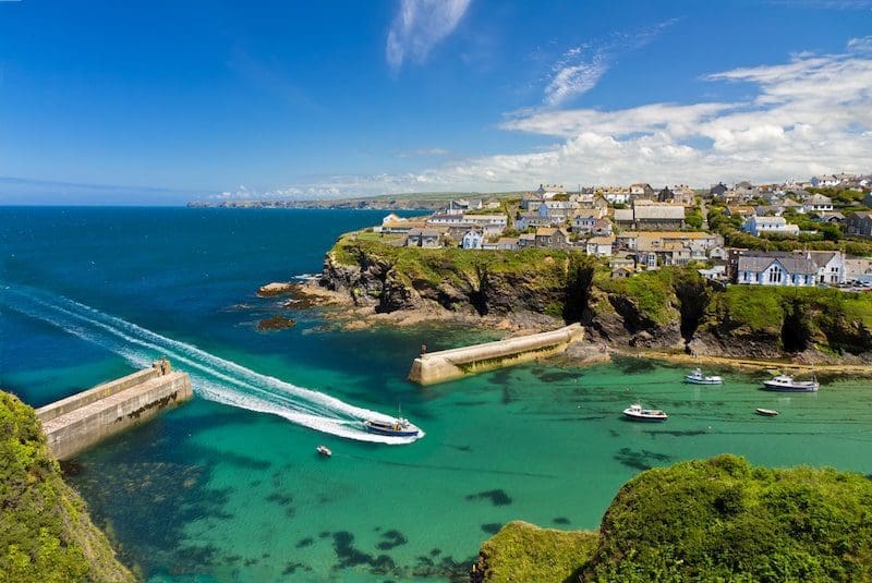 Cove and harbour of Port Isaac with arriving ship, Cornwall England