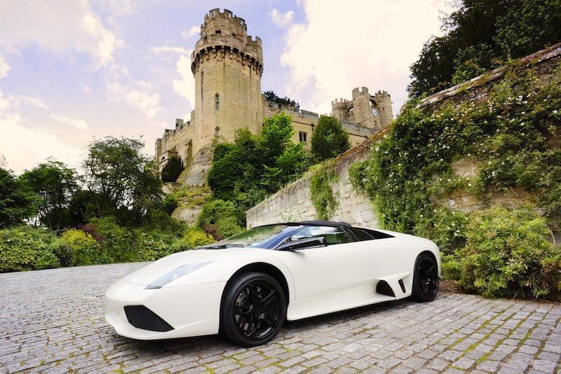 white sports car in front of castle
